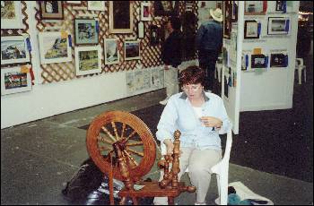 Picture of lady spinning wool.