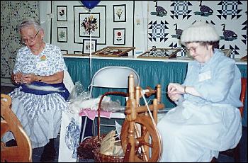 Picture of 2 ladies spinning wool into yarn.